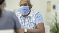Male cancer patient meets with care team wearing mask
